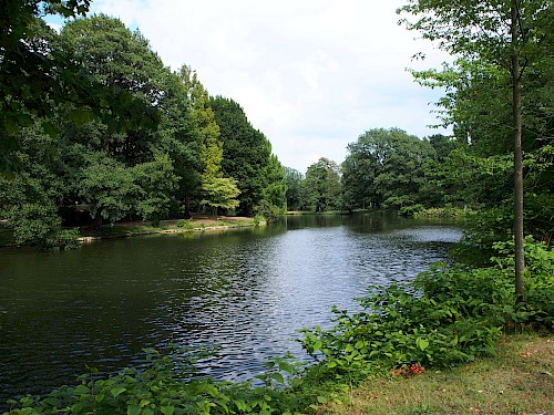 Ufer des Sees im Stadtpark Graft umgeben von Bäumen