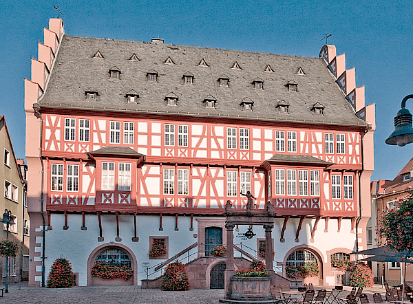 Schmuckvolle Fassade von dem Goldschmiedehaus in Hanau mit rot bemalten Holzbalken und grauer Dachstube